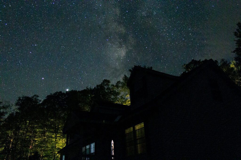 Stars at night with the silhouette of a house
